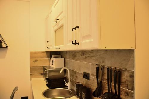 uma cozinha com armários brancos e um lavatório em Apartman Suny N58- SPA -Gratis em Kopaonik