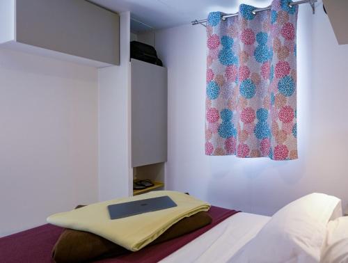 a bedroom with a bed with a window and a curtain at U Pezzo in Saint-Florent