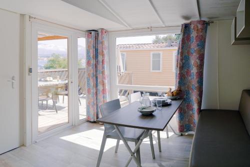 a dining room with a table and a large window at U Pezzo in Saint-Florent