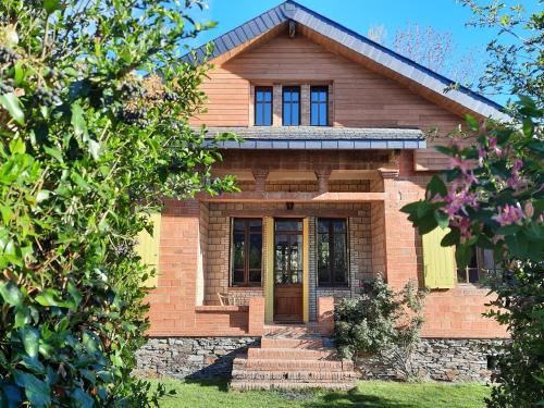 a brick house with a front door and stairs at La VILLA Luchonaise in Luchon