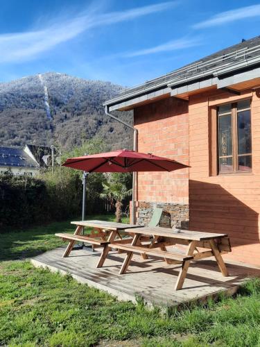 una mesa de picnic y una sombrilla en una cubierta en La VILLA Luchonaise, en Luchon