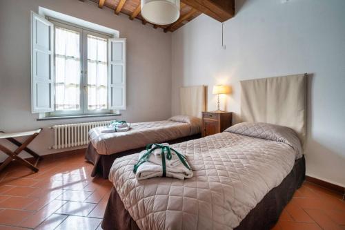a hotel room with two beds and a window at La Dimora nell'Anfiteatro Superior room and apartment Self check in Elevator Air Conditioning in Lucca