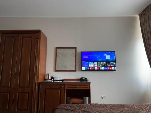 a bedroom with a desk and a tv on the wall at Hotel Ana in Constanţa