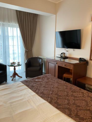 a hotel room with a bed and a desk and a television at Hotel Ana in Constanţa