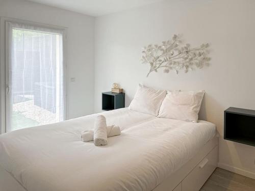 un grande letto bianco con lenzuola e cuscini bianchi di Appartement pour 4 Disneyland Paris a Montry