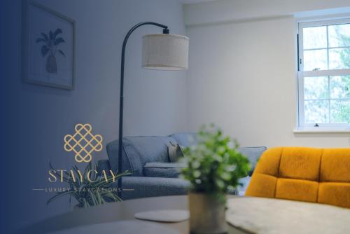 a living room with a blue couch and a table at Rock Mill - Deluxe 1-Bedroom Apartments in Stony Middleton