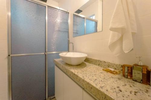 a bathroom with a sink and a shower at Espaçoso e Confortável Próximo da UEM - EL08 in Maringá