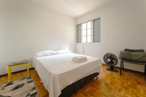 ein weißes Schlafzimmer mit einem Bett und einem Fenster in der Unterkunft Espaçoso e Confortável Próximo da UEM - EL08 in Maringá