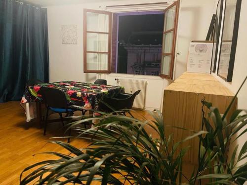 Habitación con mesa, sillas y planta en Welcome en Chambéry