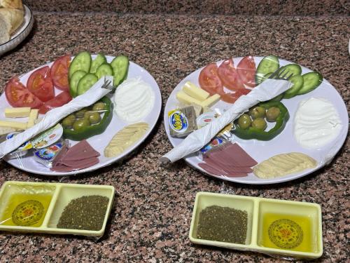 two plates of food on a counter with vegetables at Shakria Bedouin Life Camp in Wadi Rum