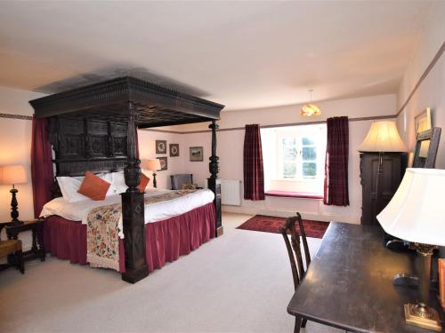 a bedroom with a bed and a table and a desk at 4 Bed in Eskdale SZ158 in Eskdale