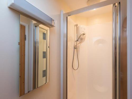 uma casa de banho com um chuveiro e um espelho. em 3 Bed in Applethwaite SZ540 em Applethwaite