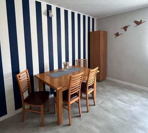 a dining room with a wooden table and chairs at eMKa Noclegi apartamenty in Augustów