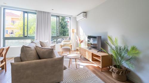 a living room with a couch and a tv at RUAH Apartments by LovelyStay in Vila Nova de Gaia