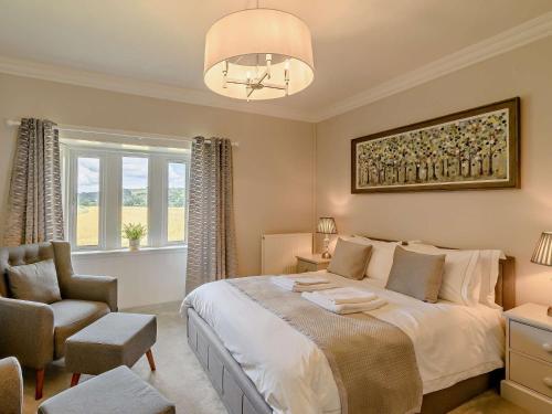 um quarto com uma cama, uma cadeira e um lustre em 2 Bed in Hawick 91905 em Roberton