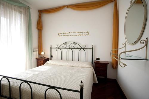 a bedroom with a bed with a mirror and a window at Residence Criro in Marina Palmense