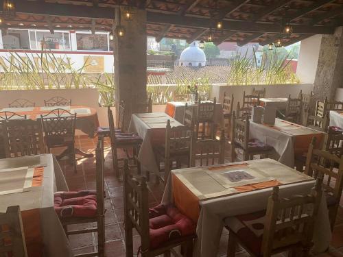 an empty restaurant with tables and chairs in a building at Hotel Boutique TEKALI INN in Cuetzalán del Progreso