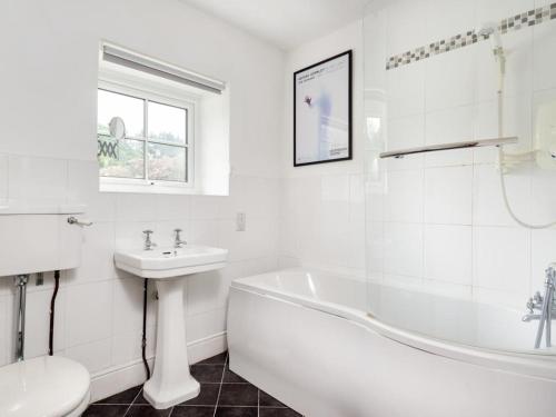 a white bathroom with a tub sink and a toilet at 6 Bed in Lamplugh SZ327 in Lamplugh