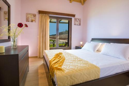 Un dormitorio con una cama con un jarrón de flores. en Villa Drimonas Artemis by Villa Plus, en Drymon