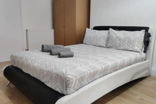 a bed with two pillows on top of it at Large Studio Garden Flat on Golders Green Road in London