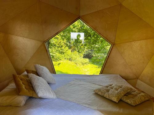 a bed in a room with a window at T'glamp Bee house in Rovte