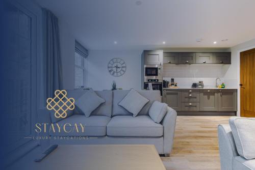 a living room with a couch and a kitchen at Rock Mill - Deluxe Holiday Apartments in Stony Middleton