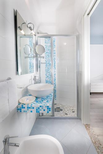 a white bathroom with a sink and a shower at Hotel Eliseo in Bellaria-Igea Marina