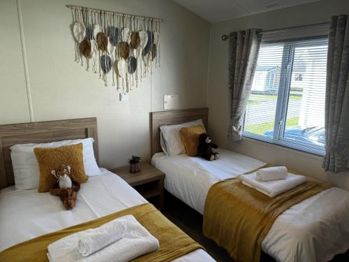 - une chambre avec 2 lits avec des ours en peluche dans l'établissement Beautiful 6 Birth Lodge - Southview Skegness, à Skegness