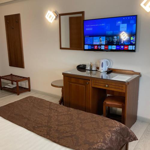 a hotel room with a desk with a tv on the wall at Hotel Ana in Constanţa