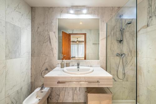 La salle de bains est pourvue d'un lavabo et d'une douche. dans l'établissement RentitSpain Charming Apartment in Parque Botanico Resort & Country Club, Marbella, Estepona, Benahavis, à Estepona
