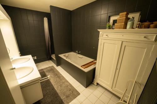 a bathroom with a sink and a tub and a toilet at Gîte " Les Demoiselles d'Ellemelle " in Ouffet