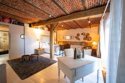 sala de estar con mesa y dormitorio en Gîte " Les Demoiselles d'Ellemelle " en Ouffet