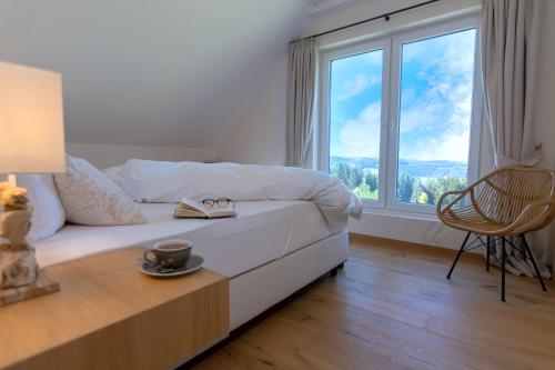 een slaapkamer met een bed en een groot raam bij Ferienhäuser Hoher Knochen in Winterberg