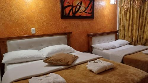 two beds in a hotel room with two bedsitures at Hotel Restaurante El Madroño Chia in Chía