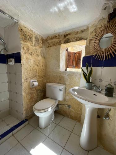 a bathroom with a toilet and a sink at Soluna Boutique Guesthouse in Għasri