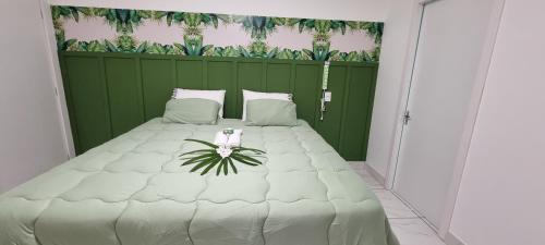 a bedroom with a large white bed with a green wall at Iguassu Jungle pousada in Foz do Iguaçu