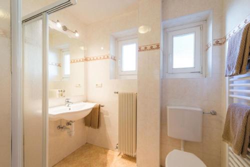 uma casa de banho com um lavatório, um WC e um espelho. em Ferienwohnung in den Dolomiten mit traumhafter Aussicht em Kastelruth