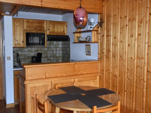 une cuisine avec une table en bois et une table et des chaises dans l'établissement Appartement cosy 4 pers avec balcon, centre de Pralognan, proche commerces et télécabine - FR-1-464-185, à Pralognan-la-Vanoise