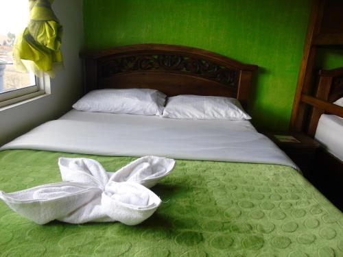 a bed with two white towels on top of it at Hotel Restaurante El Madroño Chia in Chía