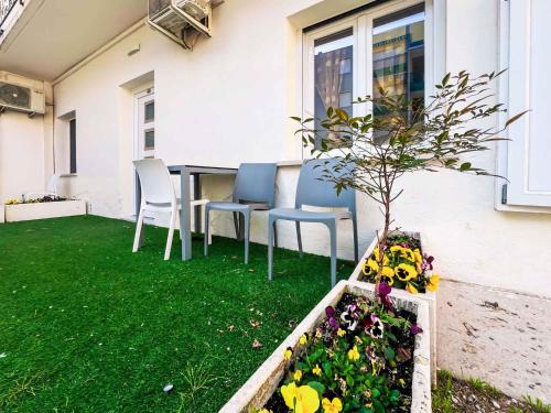 un patio avec une table, des chaises et des fleurs dans l'établissement Apartments in Bibione 45652, à San Michele al Tagliamento