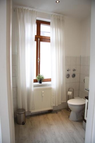 a bathroom with a toilet and a window at Peters Apartments - Zentrale Innenstadtlage in Fulda