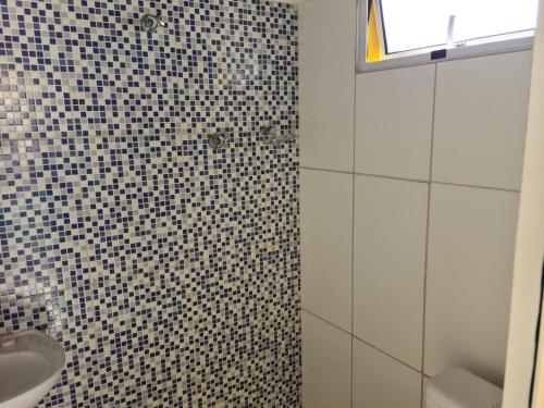a bathroom with a black and white tiled wall at Casa Super em São Miguel do Gostoso RN in São Miguel do Gostoso
