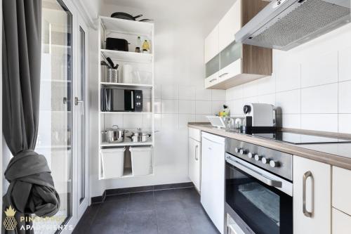 a kitchen with white cabinets and a stove top oven at Pineapple Apartments Studio-Apartment am Zwinger in Dresden