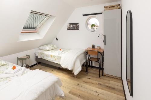 a bedroom with two beds and a desk in it at New, quiet apartment close to Basel in Saint-Louis