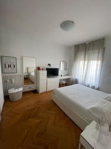 a bedroom with a bed and a desk and a kitchen at Cadolini Apartment in Milan