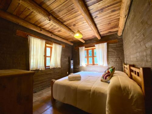 Un dormitorio con una cama grande en una habitación con techos de madera. en Aldea punta de agua, en Sayula