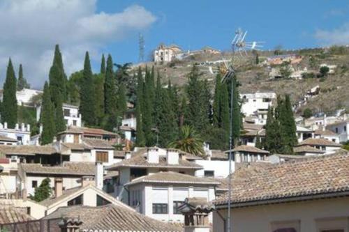 a city with houses and trees on a hill at Apartamento Casa Ruan Albaicín, Torre de Comarex in Granada