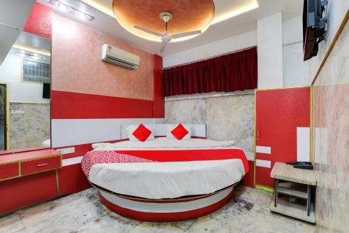 a red and white bedroom with a bed and a tub at OYO Flagship Hotel Ravi Palace in Rajkot