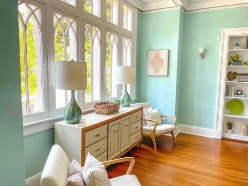 ein Wohnzimmer mit blauen Wänden und 2 Fenstern in der Unterkunft Timeless Charm: Discover the 1918 CE Smith House! in Little Rock