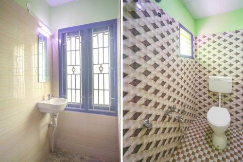 a bathroom with a toilet and a sink at Hotel O Sakthi Guest House in Chidambaram